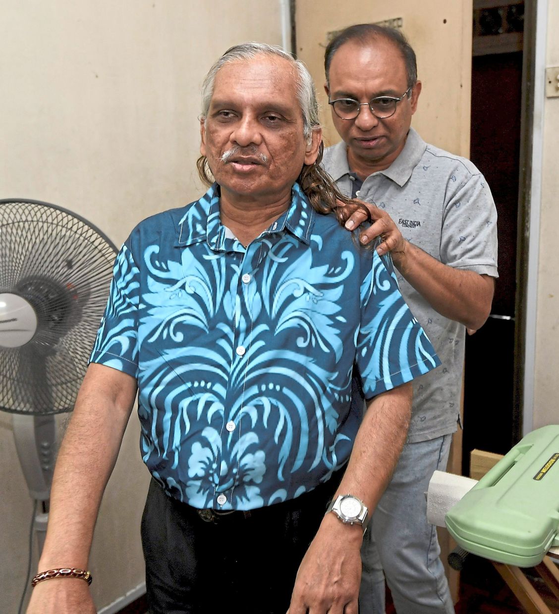 Louise (front) being assisted around his office by his brother Joseph.