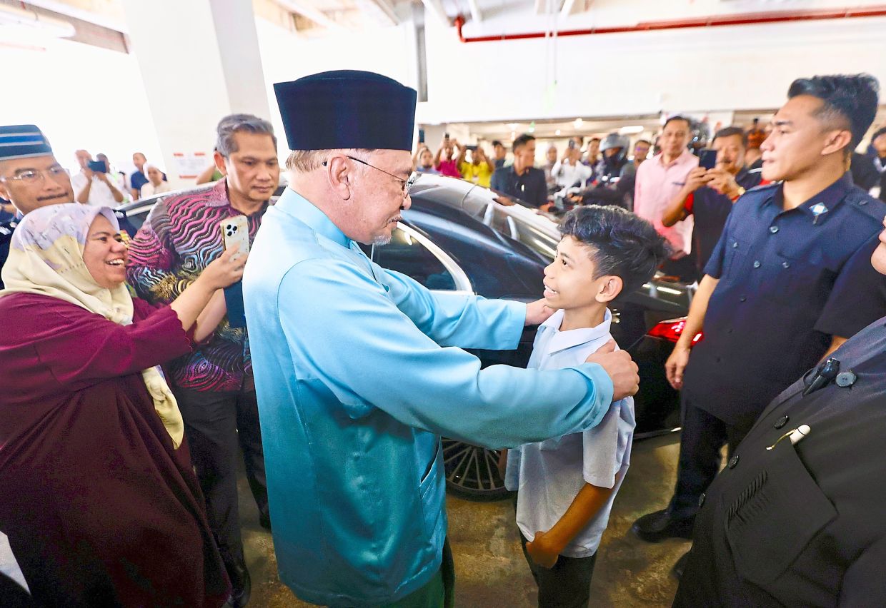 Hello there: Anwar meeting with the public after Friday prayers in Putrajaya. — FAIHAN GHANI/The Star