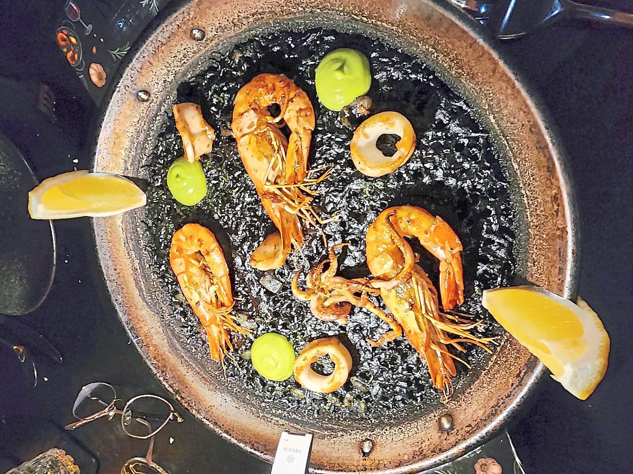 The squid ink paella is an aquatic-centric treat that is accentuated by a rich assortment of fresh seafood. — ABIRAMI DURAI/The Star