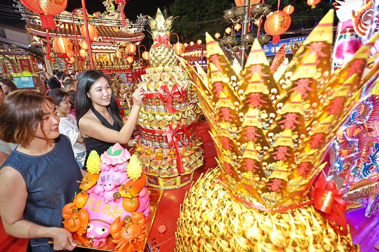 Visitors looking at some of the elaborate offerings on the altar during the Jade Emperor’s birthday celebration at Chew Jetty in George Town.