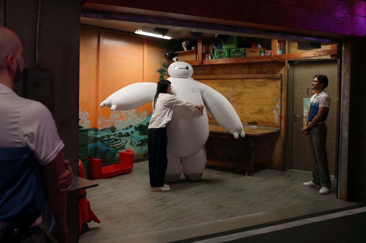 A Walt Disney employee hugs Baymax onboard the Disney Adventure cruise ship at Marina Bay Cruise Centre in Singapore, on Monday, March 9, 2026. -- Photo: REUTERS/Edgar Su