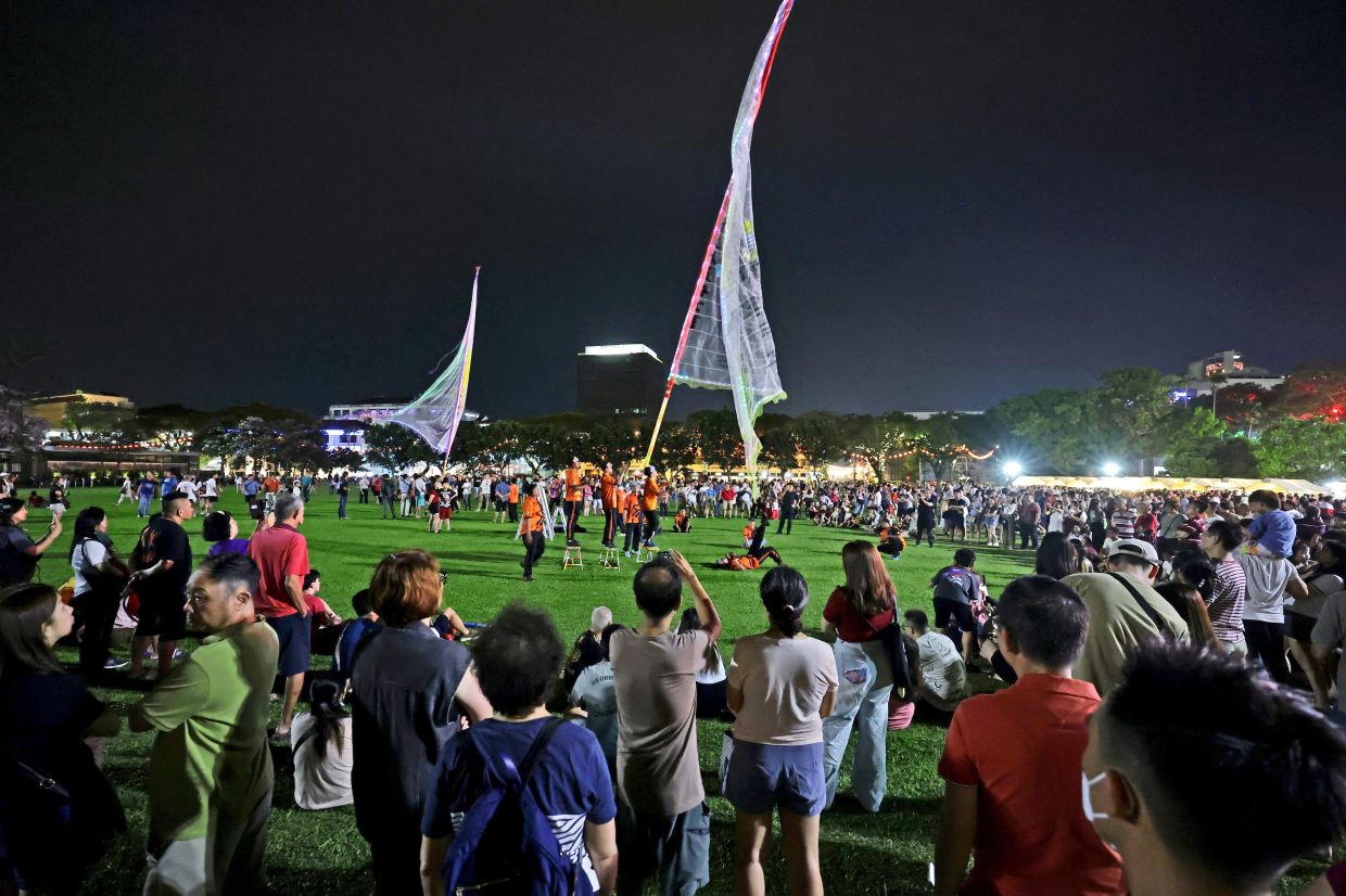 Spectators captivated by the Chingay display.— Photos: CHAN BOON KAI and K. KASTURI DEWI/The Star