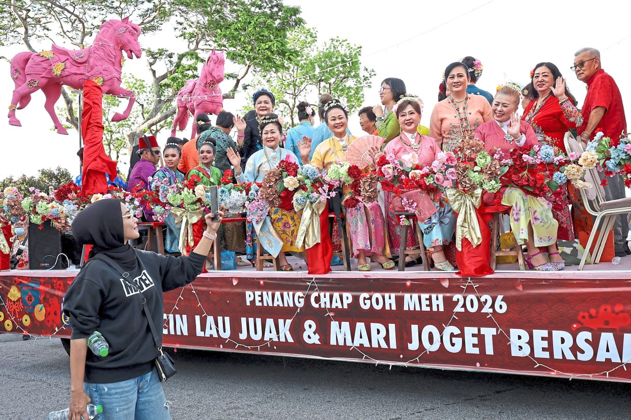 Dondang sayang’ performers dressed in vibrant kebaya and traditional attire on one of the colourful floats. — Photos: CHAN BOON KAI and K. KASTURI DEWI/The Star