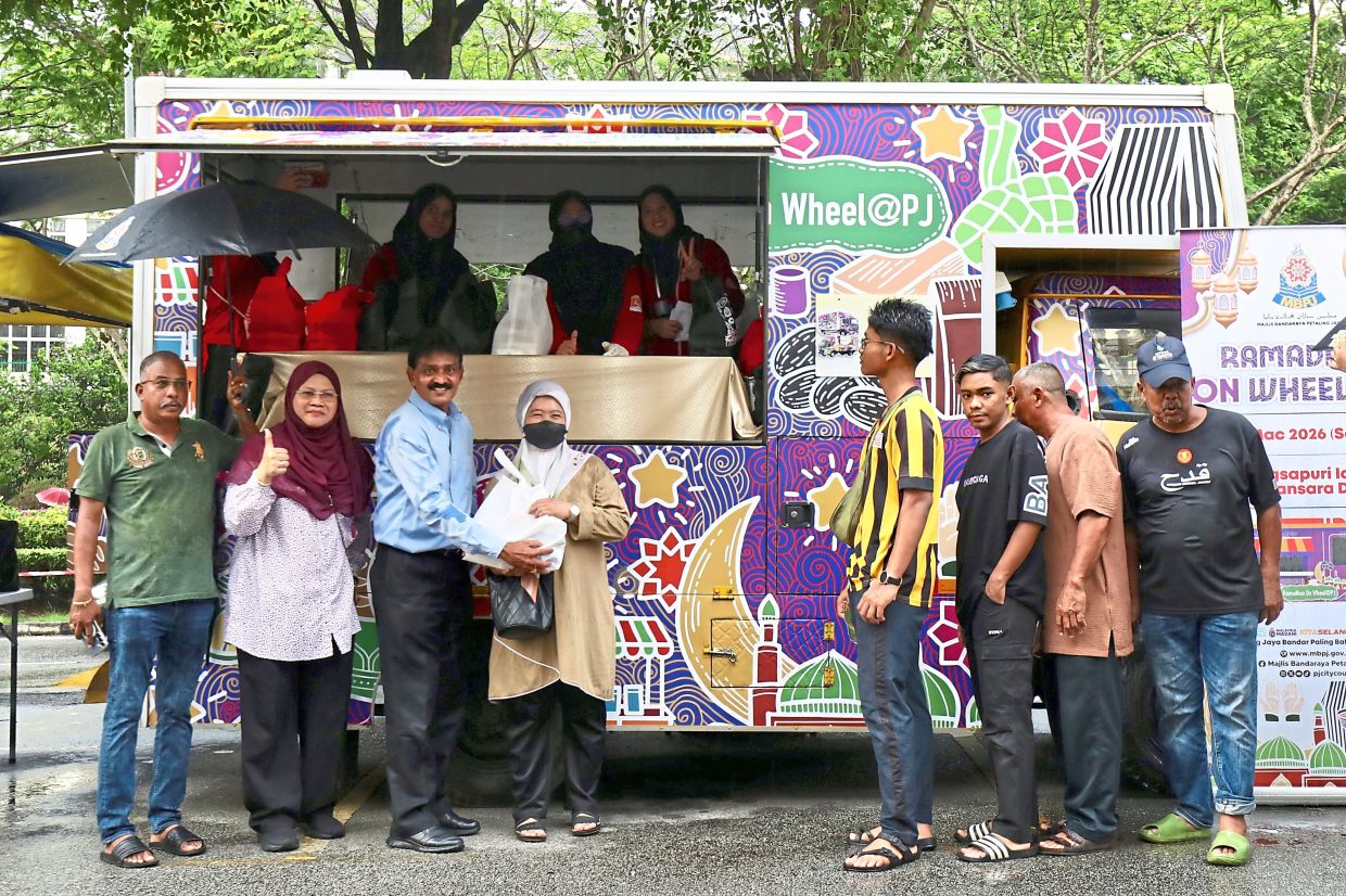 (Second and third from left) Sharinaz and Suriase distributing food as part of the ‘Ramadan On Wheels@PJ’ initiative in Petaling Jaya. — Photos: LEONG WAI YEE/The Star