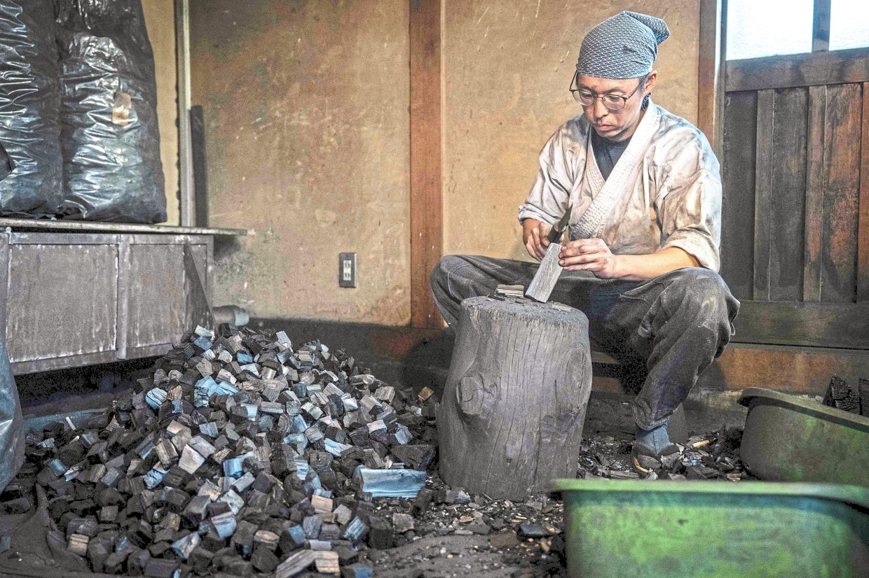 Forging talent: Apprentice Toru Watanabe breaking up charcoal at Kawasaki’s workshop in Misato, Saitama prefecture. — AFP 