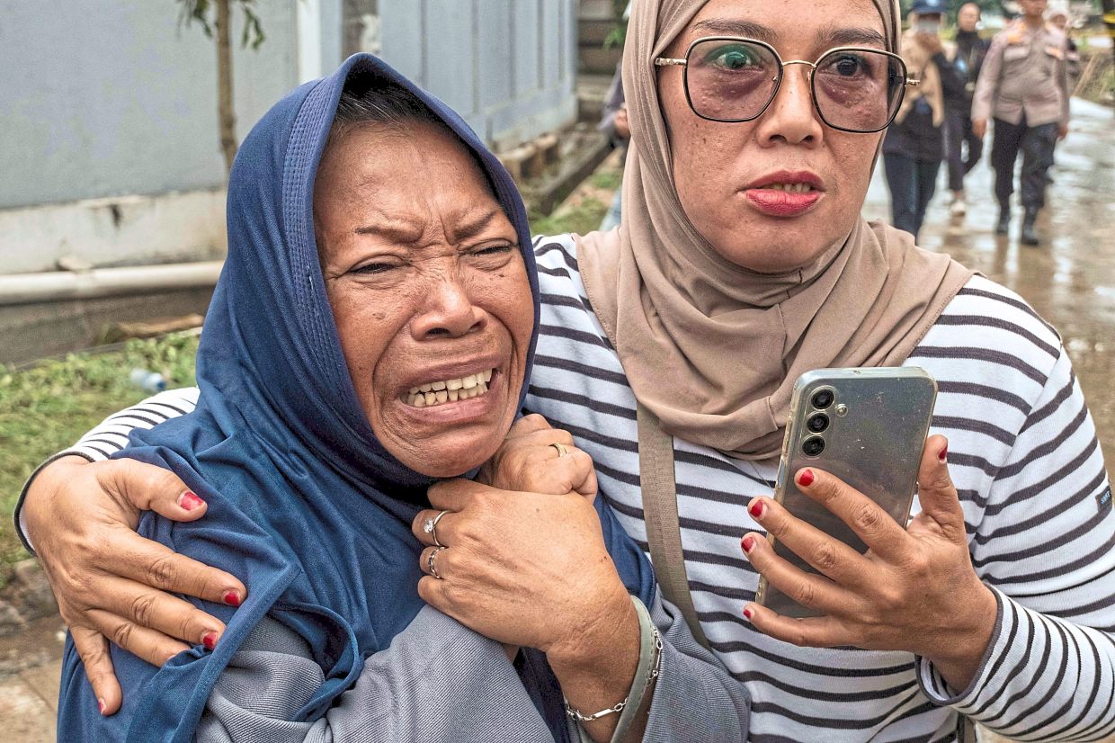 A woman in anguish after the body of a victim was recovered. — AFP 