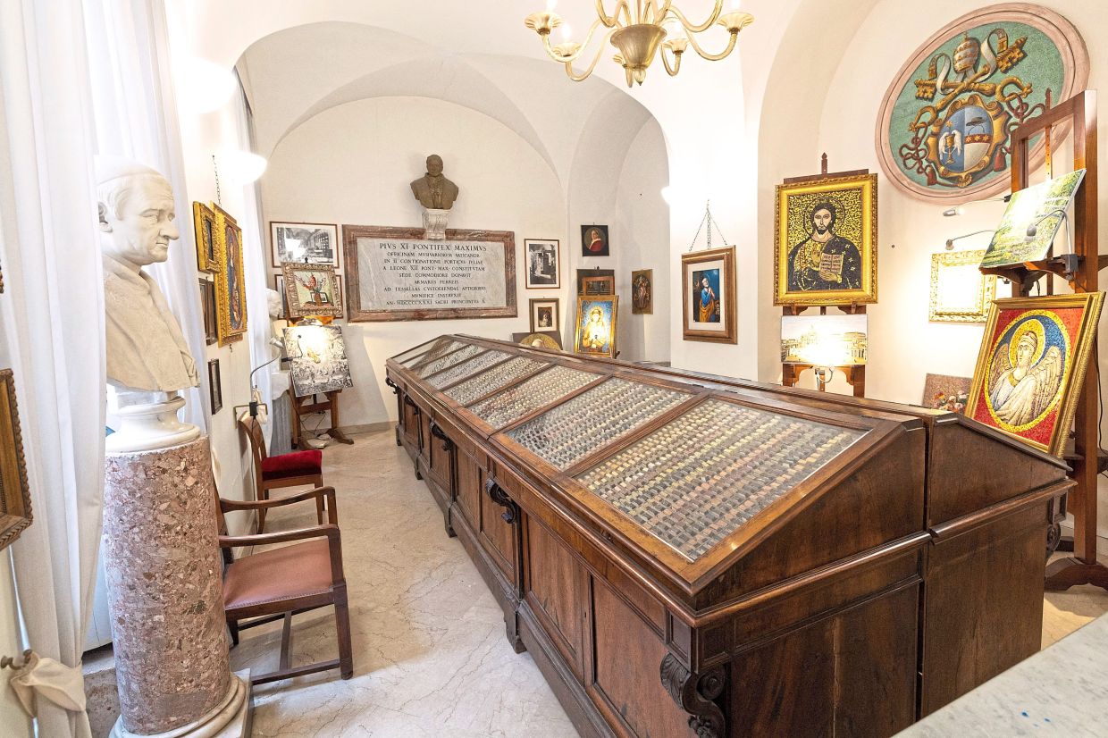 The showroom of the Vatican Mosaic Studio, featuring cases filled with coloured mosaic tiles and framed artworks. — Reuters 