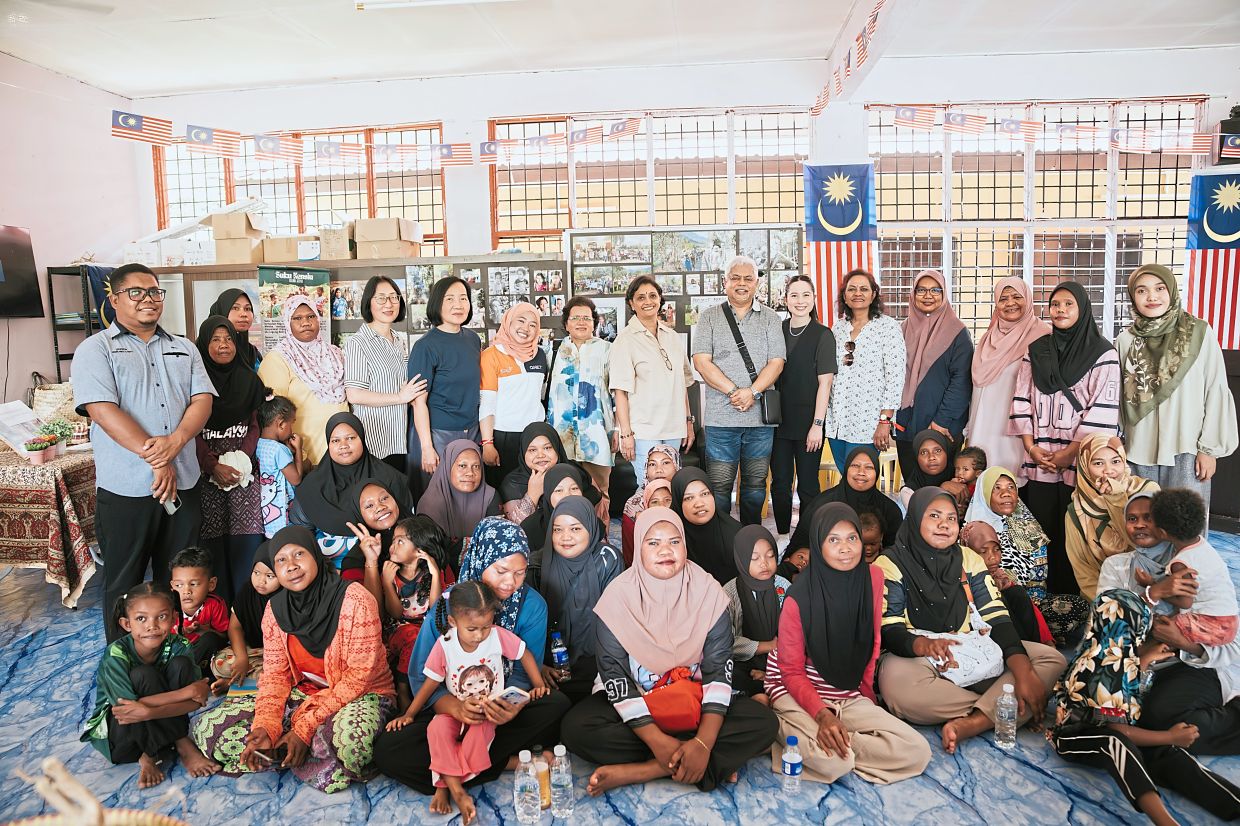 Umayal (standing, eighth from right) and her team (from QI Group) with the Orang Asli community in Kedah.