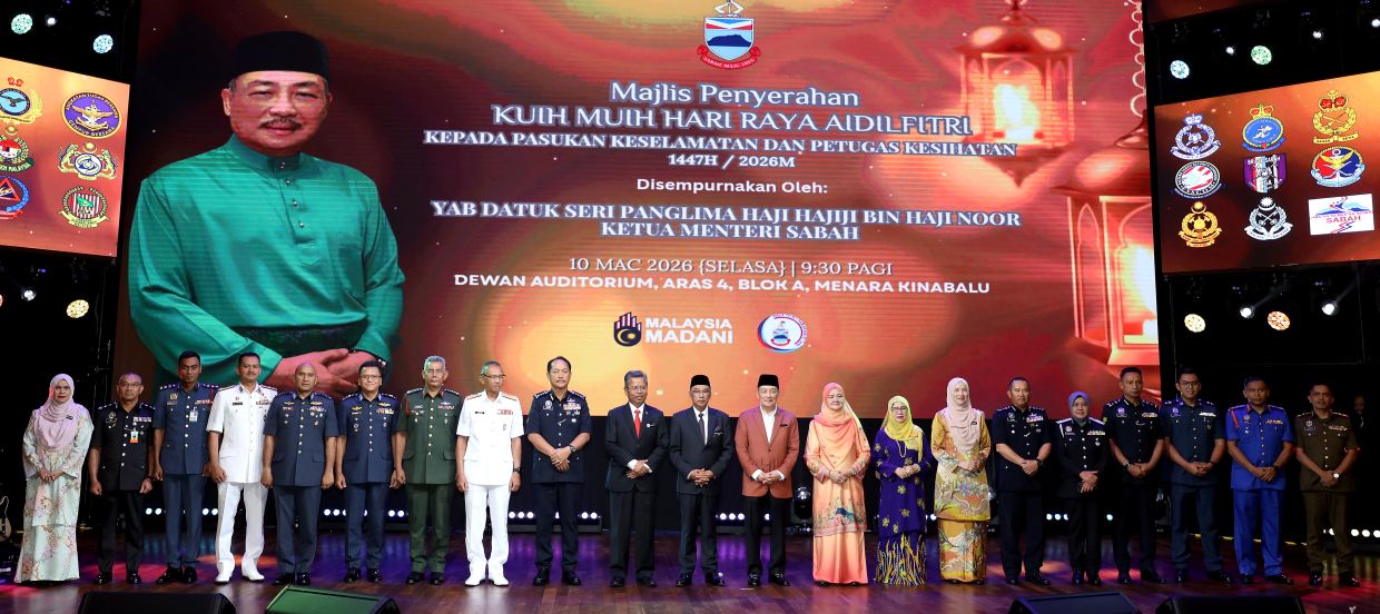 Chief Minister Datuk SeriHajijiNoor and wife Datin Seri Juliah Salag (centre) with the security and health personnel in Kota Kinabalu.