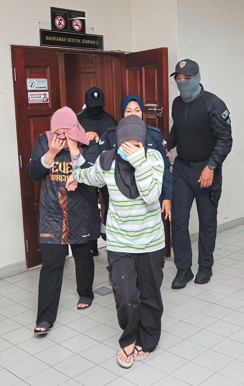 Including two women (right) who were charged for being members of an organised crime group. — ZHAFARAN NASIB/The Star