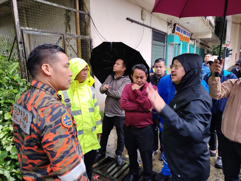 Sandakan Municipal Council president Walter Kenson (right) speaking to emergency responders during a site visit to the landslide area near Block 10 along Lebuh 4 in Sandakan town centre.