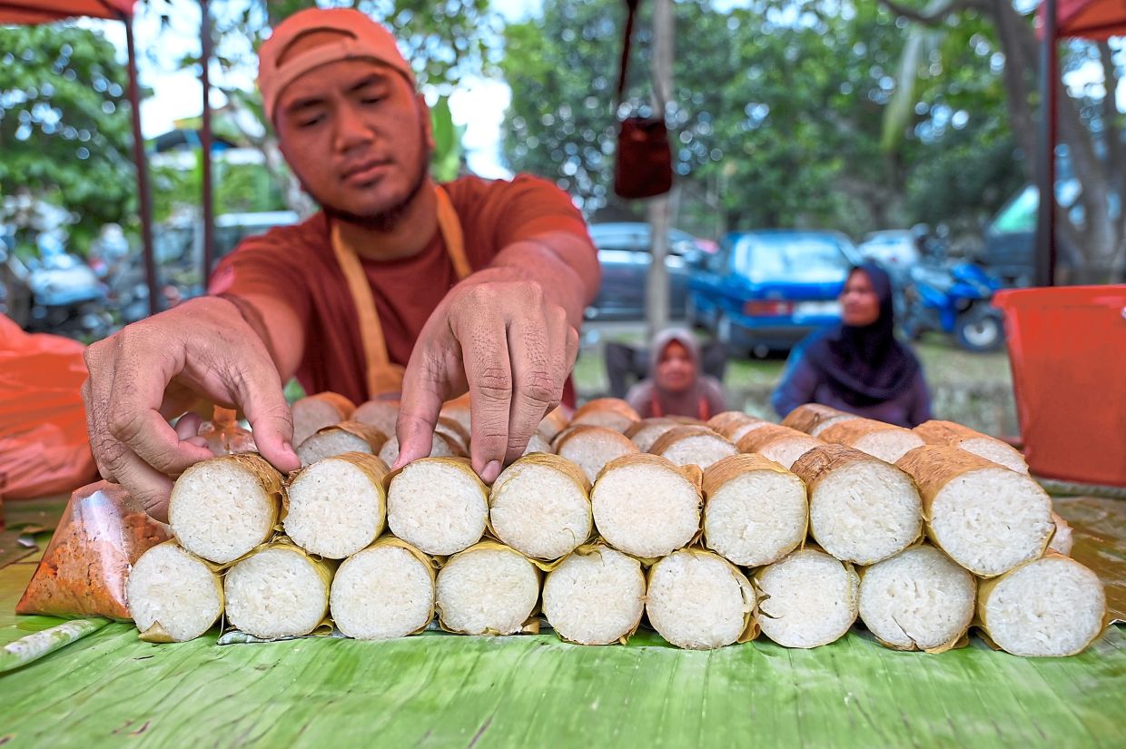 [Optional] Abdul Halim Jamhur, 26, arranging sticks of lemang at his Ramadan bazaar stall in Jalan SS 5c/13, Kelana Jaya. — IZZRAFIQ ALIAS/The Star
