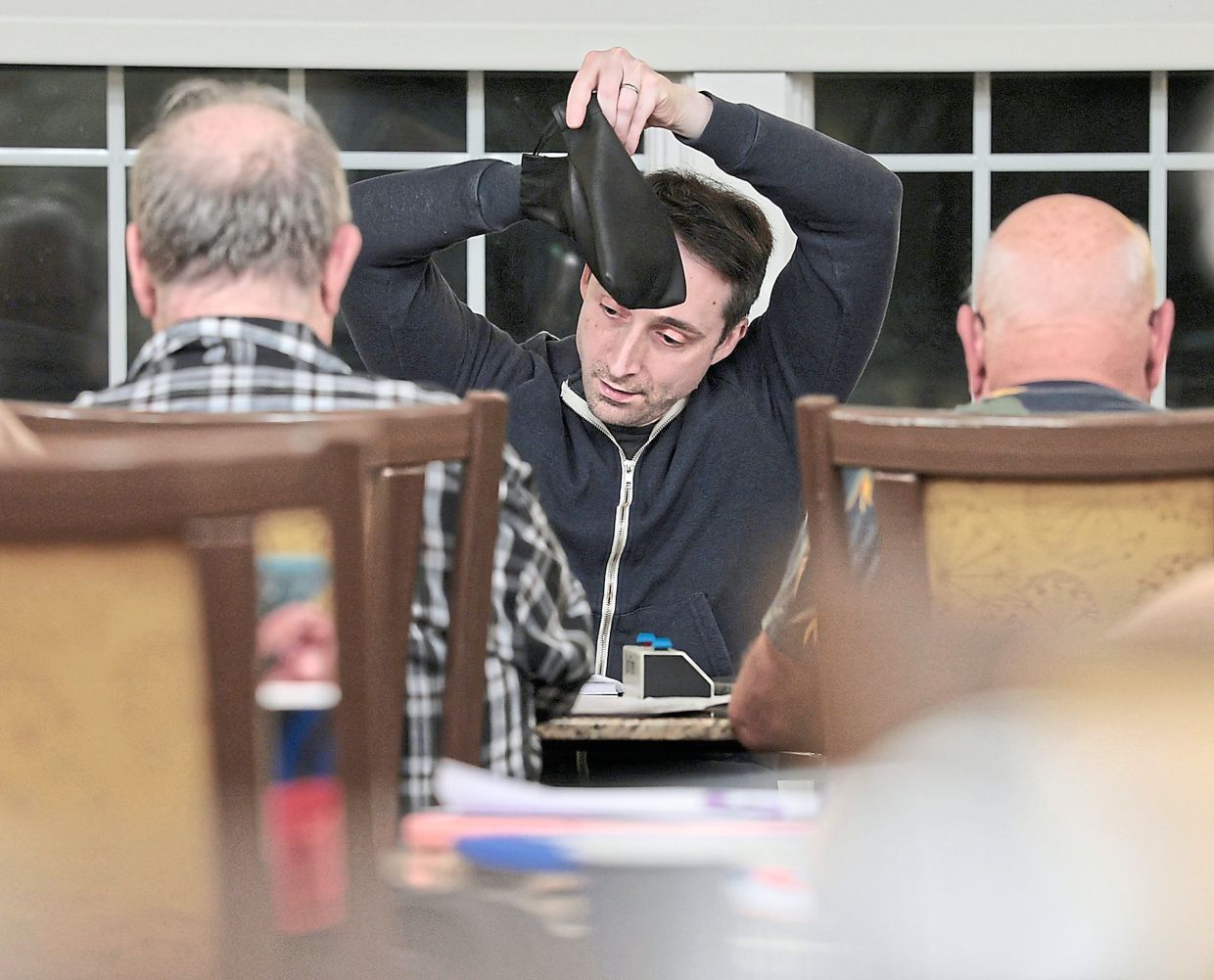 Anderson picks his tiles from the bag while playing Scrabble during a Scrabble group meetup at Riddle Village.