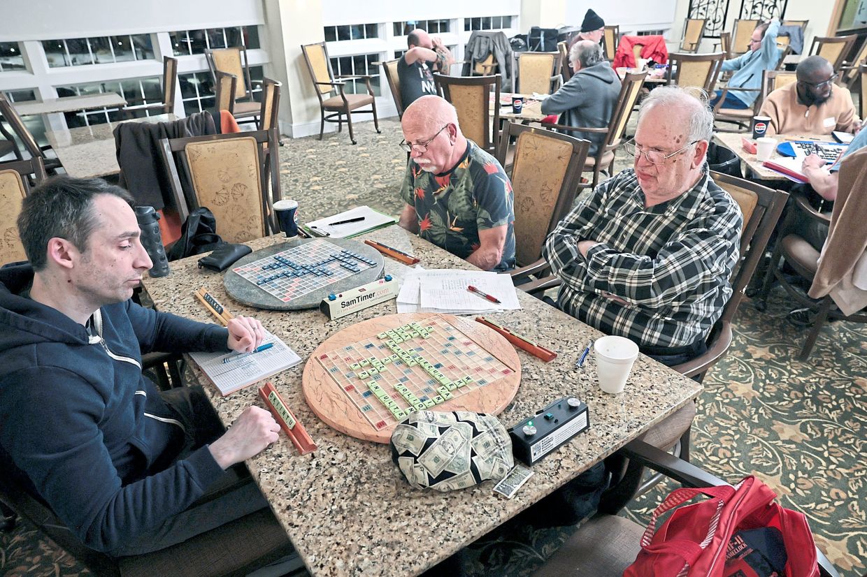 Anderson (left) plays Joe Petree (middle) and Marty Fialkow (right) during a Scrabble group meetup.