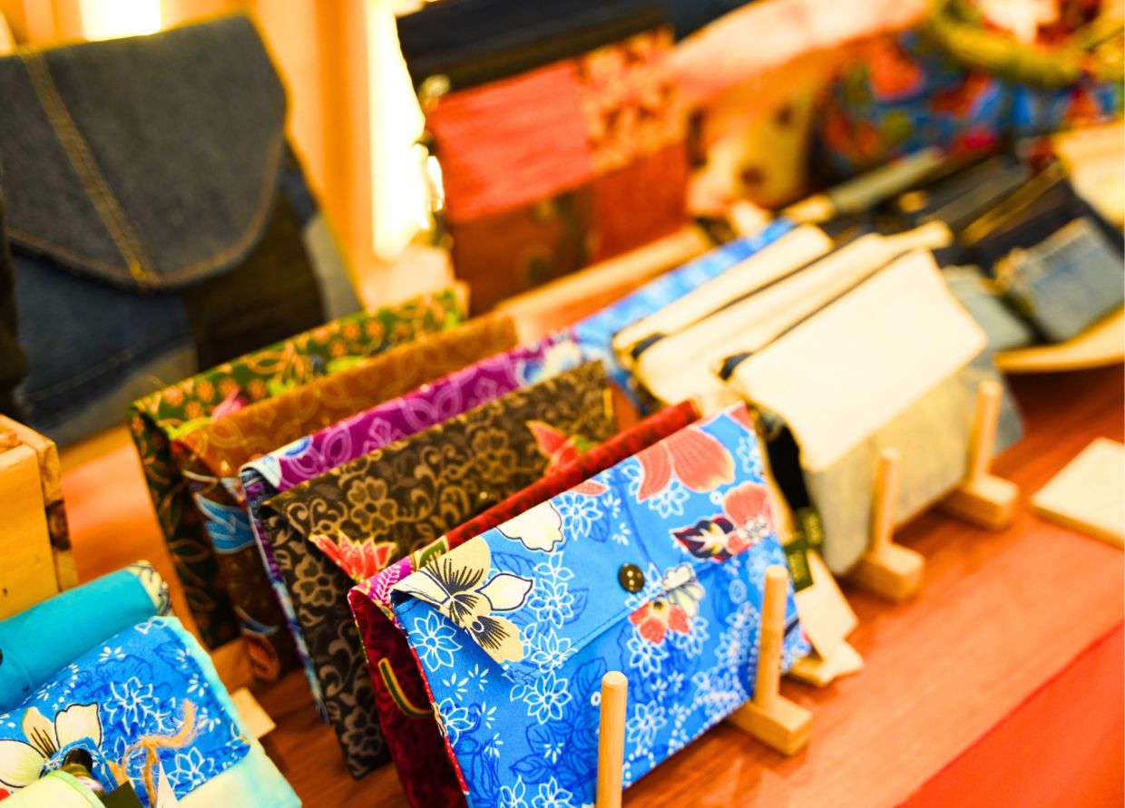 Handcrafted Suri Raya pouches are available through the mall's redemption programme, supporting underprivileged mothers in Klang and Langkawi. 