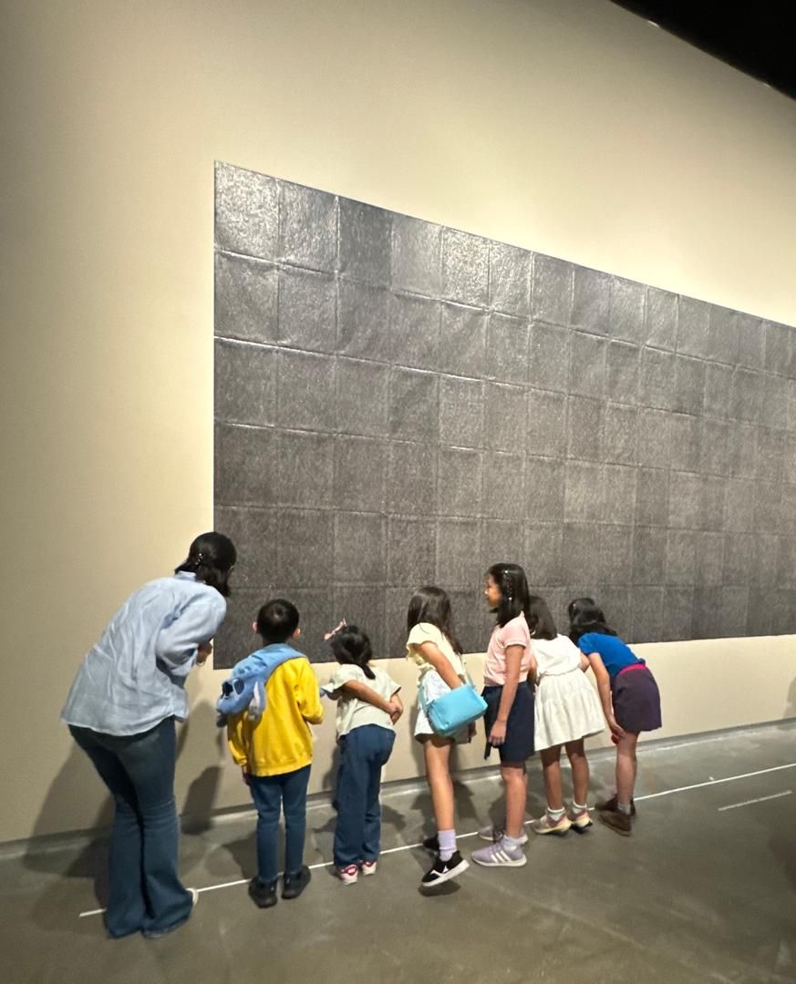 Ilham Kids’ Art Discovery Tours participants investigating artist Kim Ng’s 'A State Of Resilience' wall installation at the 'Ilham Art Show 2025' in KL. Photo: Handout