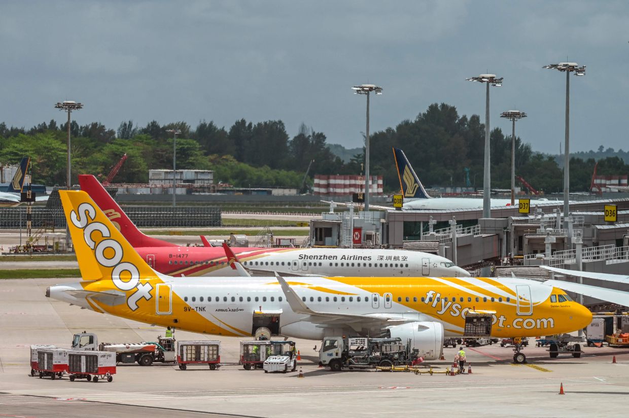 A Scoot passenger jet is pictured at Singapore Changi Airport in Singapore on Friday, March 13, 2026. Some Asian airlines have begun hiking ticket fares in response to energy concerns arising from war in the Middle East that have driven up oil prices. -- Photo by Roslan RAHMAN / AFP