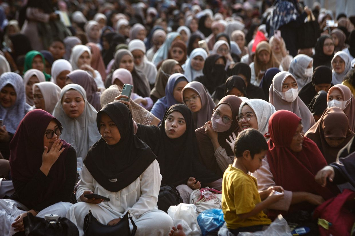 Indonesian Muslims gather for iftar, the evening meal that breaks the daily fast during the Muslim holy month of Ramadan, during a mass iftar event hosted by the Russian Muslim Spiritual Council to strengthen ties between Russia and Indonesia at the Istiqlal Grand Mosque in Jakarta, on Saturday, March 14, 2026. -- Photo by Aditya Irawan / AFP