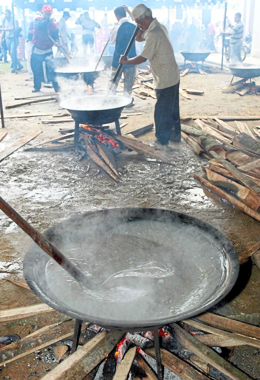 The stirring of dodol, a chewy, sticky and toffee-like confection made of palm sugar, coconut milk and glutinous rice flour, is a common homestay activity during Hari Raya. — RAJA SHAMSUL/The Star