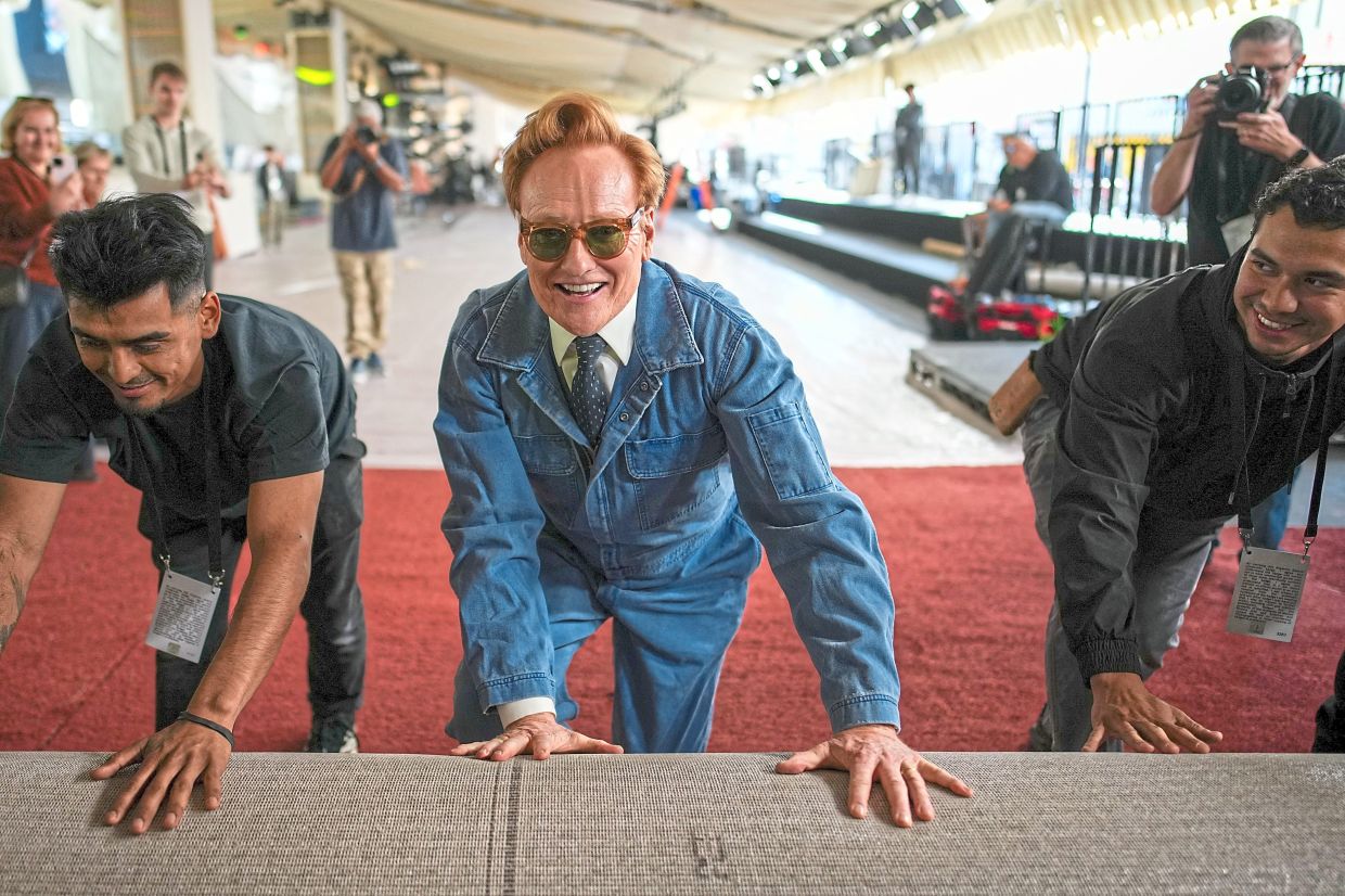 Returning host O’Brien (centre) rolls out the red carpet. Photo: Reuters