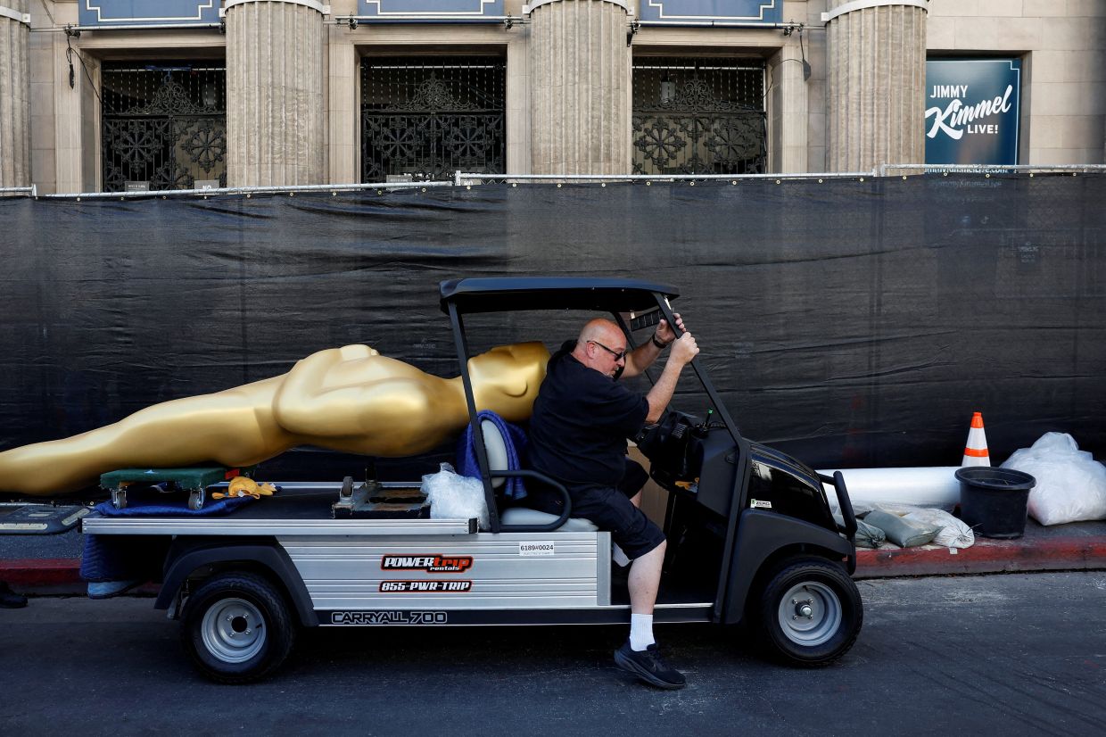 Workers transport a large Oscar themed decoration outside the red carpet as preparations for the 98th annual Academy Awards. Photo: Reuters