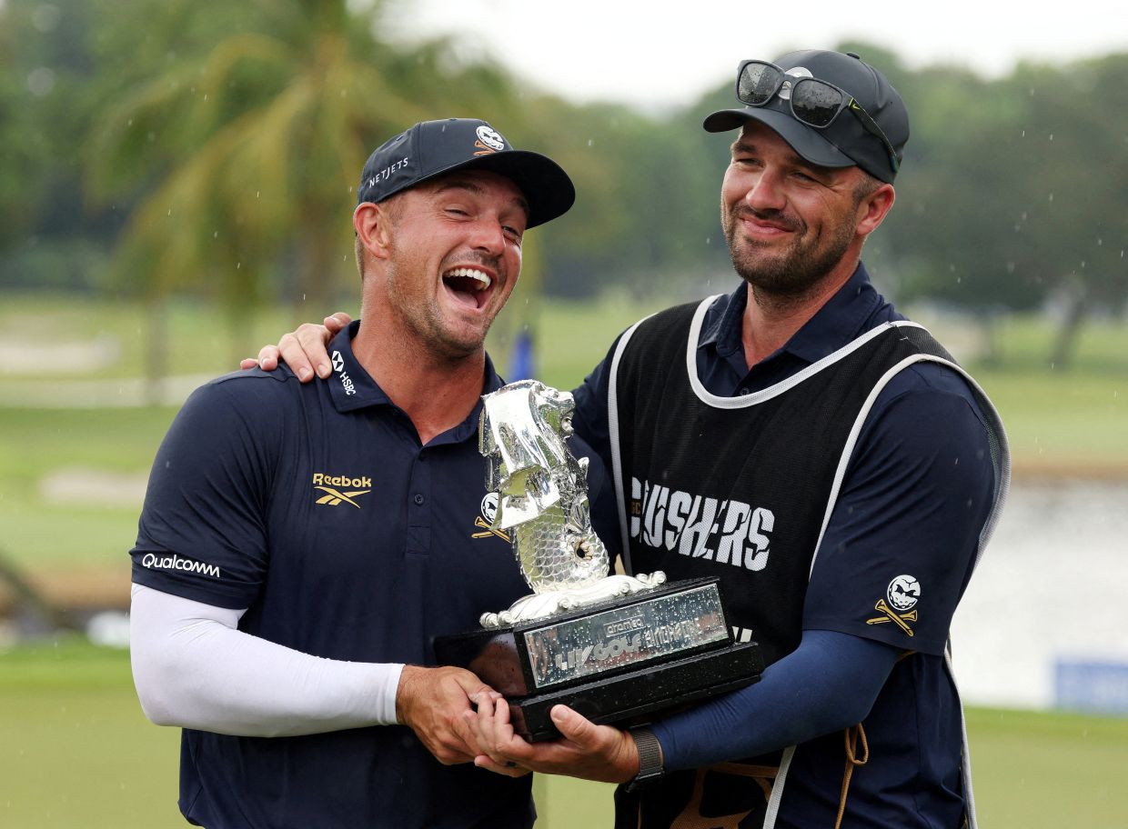 Golf - LIV Golf - Singapore - Sentosa Golf Club, Singapore - March 15, 2026; Crushers GC's Bryson DeChambeau celebrates with his trophy after winning the LIV Golf Singapore -- Photo: REUTERS/Edgar Su