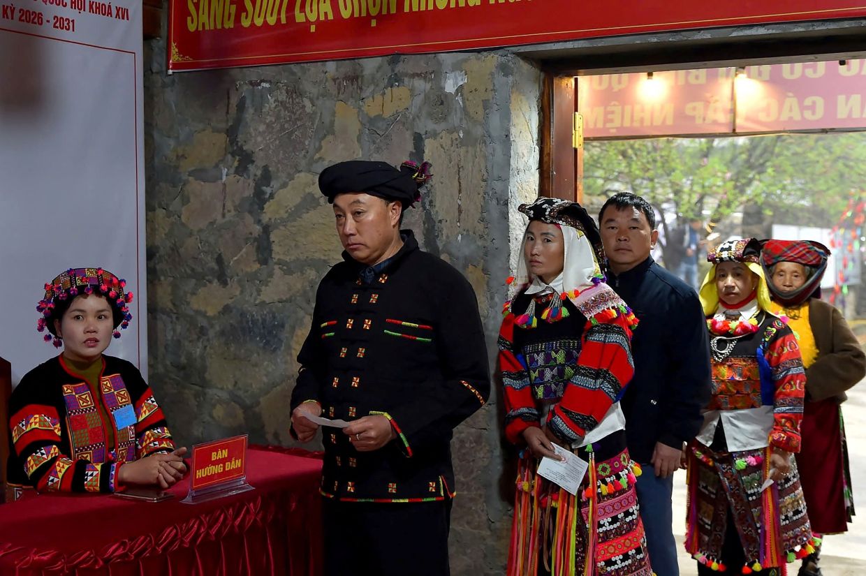 Ethnic minority citizens line up to cast their votes inside a polling station in the northern Vietnamese province of Tuyen Quang on Sunday, March 15, 2026. Polls opened in Vietnam with voters casting ballots for members of the National Assembly, the country's top legislative body that serves mainly to ratify decisions by the ruling Communist Party. -- Photo by -STR / AFP