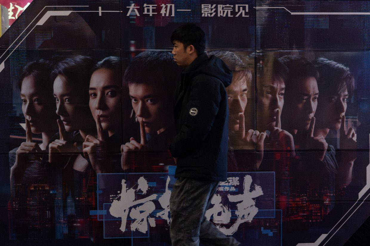 A man walks past a promotion board for Scare Out, at a cinema in Beijing. The Chinese movie that marks the first motion picture to be endorsed by China's secretive and powerful Ministry of State Security. (AP Photo/Ng Han Guan)