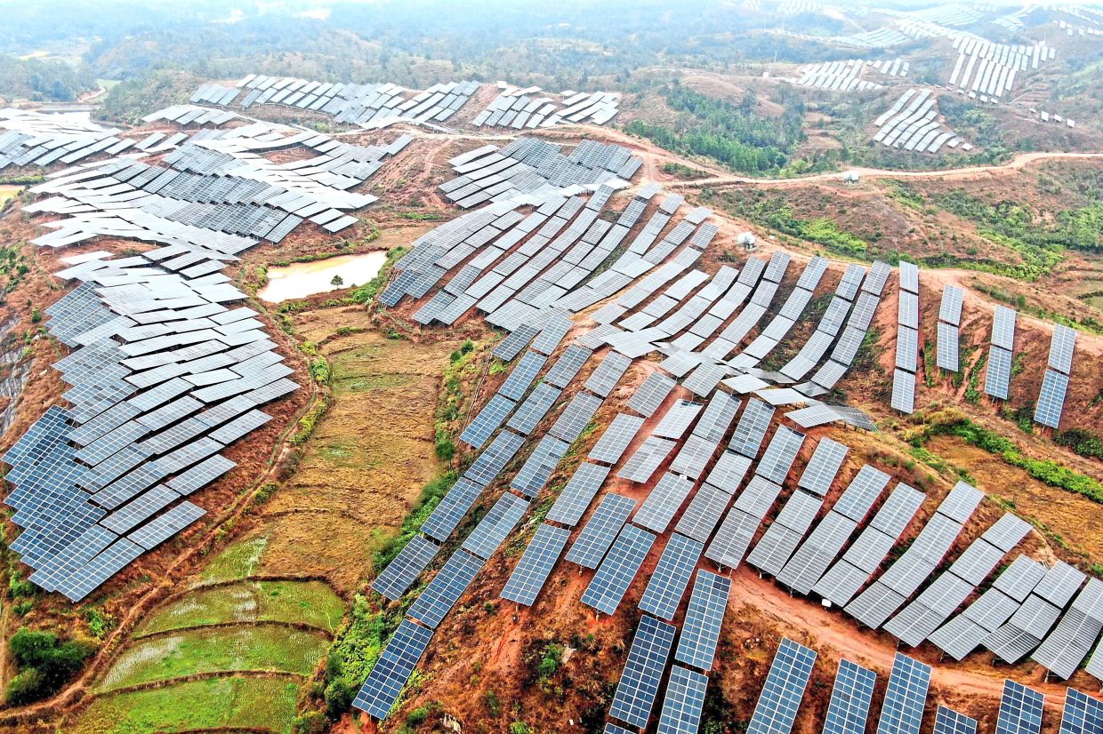 Solar panels covering mountainsides around Xinxi Village, Suichuan County, China. If Malaysia is to exit coal by 2035 as pledged, it must accelerate decentralised renewable energy and reform the power grid so it is much less dependant on fossil fuels. — CN-STR/AFP