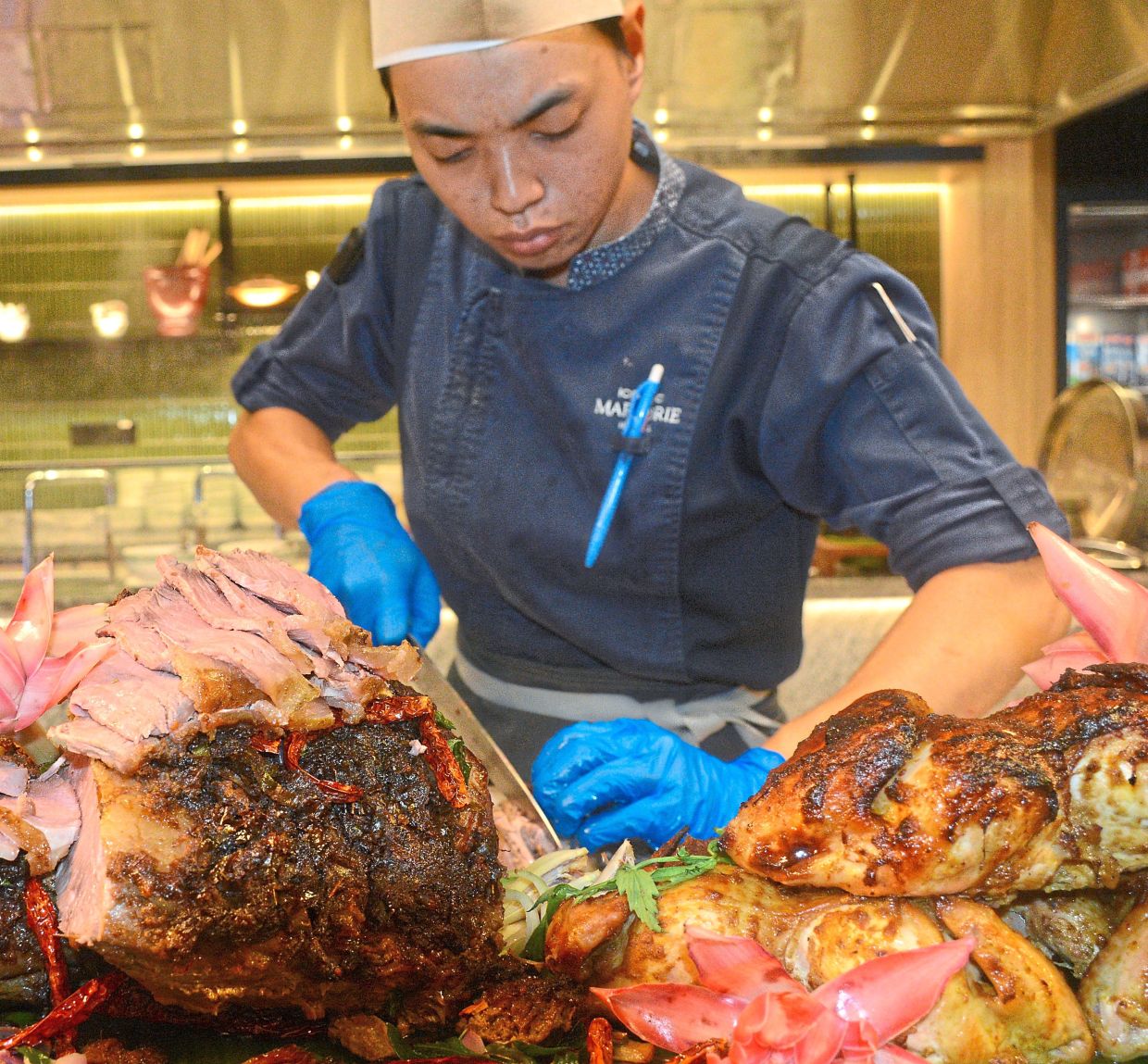 A chef preparing meats at the Bakar Bakar station as part of the buffet at Iconic Marjorie Penang. 