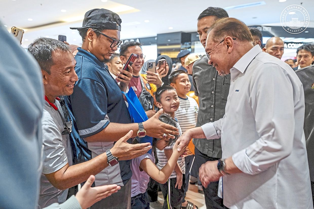Nice to meet you: Anwar sharing a light moment with attendees at the National Consumers Day launch in Kota Kinabalu. — Photo courtesy of the Anwar Ibrahim Facebook page