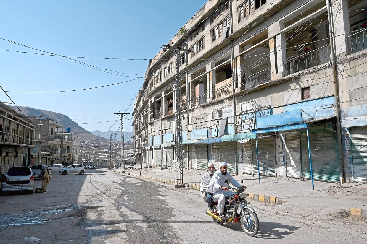 Men riding a bike past the closed Landi Kotal Bazaar near the Torkham border between Afghanistan and Pakistan amidst the ongoing clashes between the two countries. Afghanistan said it downed a Pakistan fighter jet and captured its pilot on Feb 28, a claim denied by Islamabad a day after it declared an ‘open war’ with its South Asian neighbour. — AFP