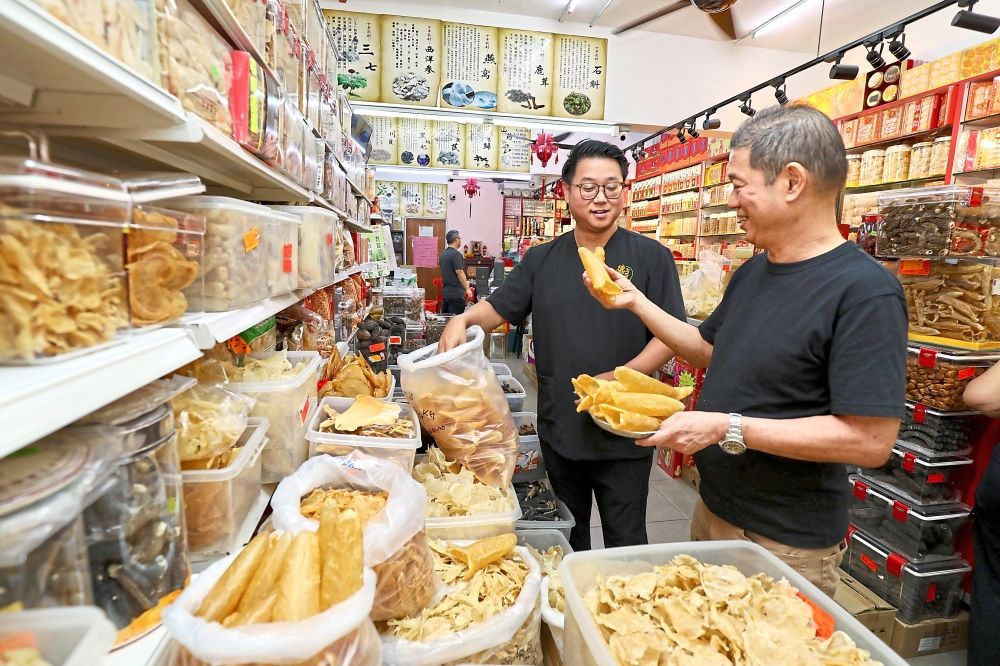 Premium offerings: Chin Chee Khai and son Kenneth Chin checking on imported fish maw at their medicine hall in Petaling Jaya, Selangor, which marries traditional healing practices with operational digitalisation. — LEONG WAI YEE/The Star