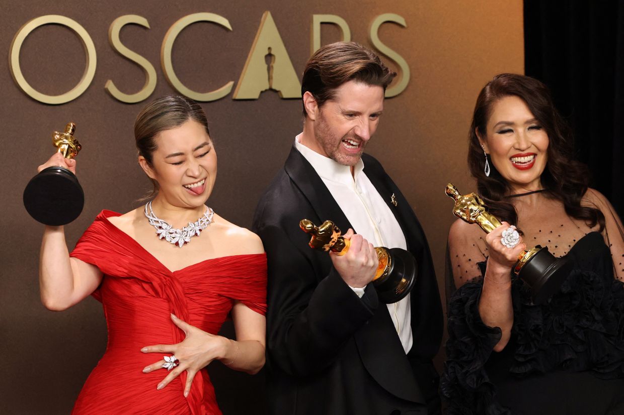 Maggie Kang, Chris Appelhans and Michelle L.M. Wong pose with the Oscar for Best Animated Feature Film for 'KPop Demon Hunters'. Photo: Reuters