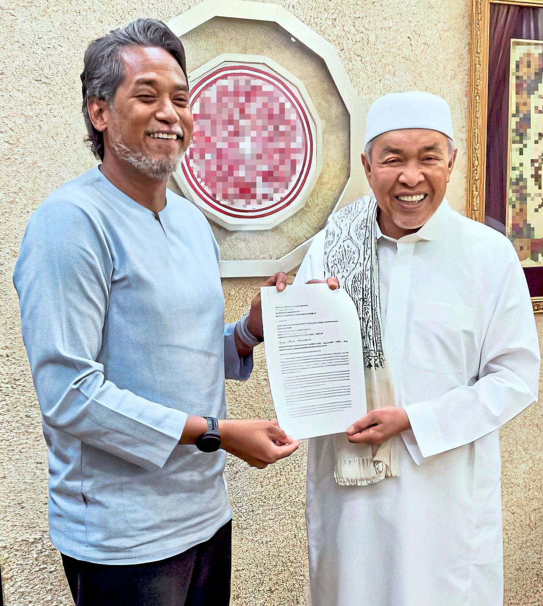 Reunited: Ahmad Zahid (right) receiving an appeal letter to rejoin Umno from Khairy. — Photo taken from Ahmad Zahid’s Facebook page