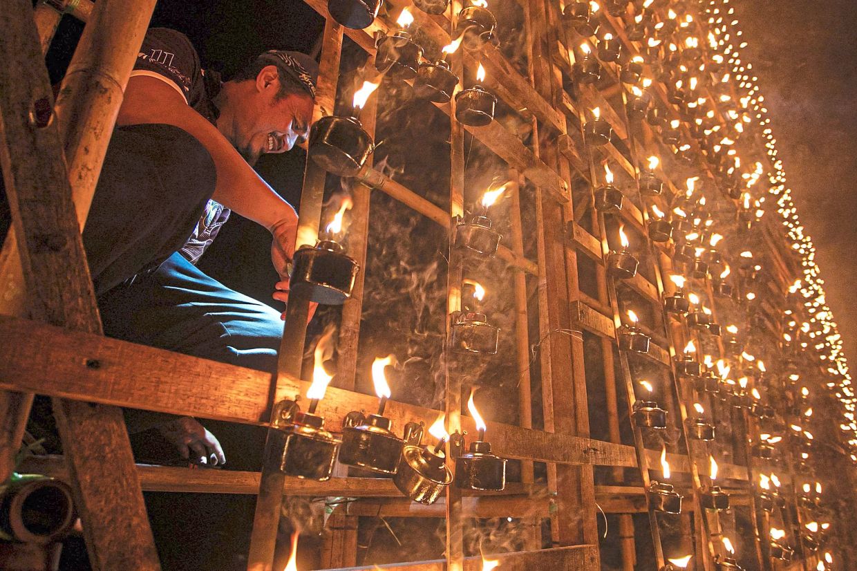 Since its inception in 2014, the programme has used 1,000-1,400 panjut lamps annually, with some 130-150 bamboo poles needed to construct themed structures, including designs of the country’s iconic mosques. Photo: Bernama