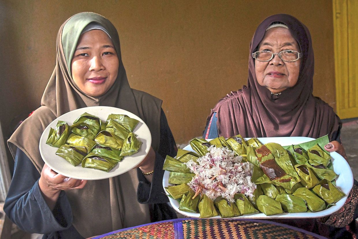 Meriam (right) and her daughter Norihawati showing the lepat they made with chica powder. 