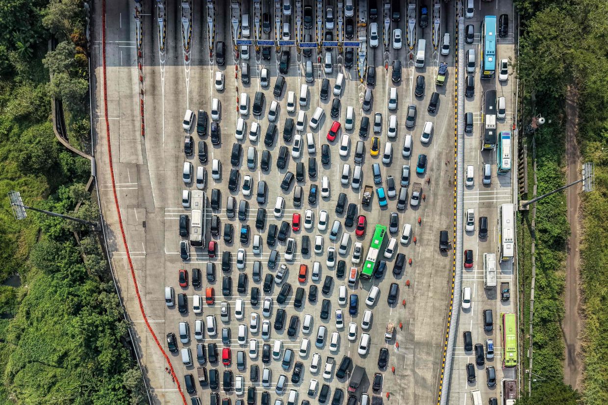 This aerial picture shows vehicles stuck in a traffic jam on the freeway heading out of Jakarta at a toll booth in Cikampek, West Java, on Tuesday, March 17, 2026, as people are heading to their hometowns for the upcoming Eid al-Fitr (Hari Raya) festivities, which mark the end of the Muslim holy fasting month of Ramadan. -- Photo by BAY ISMOYO / AFP