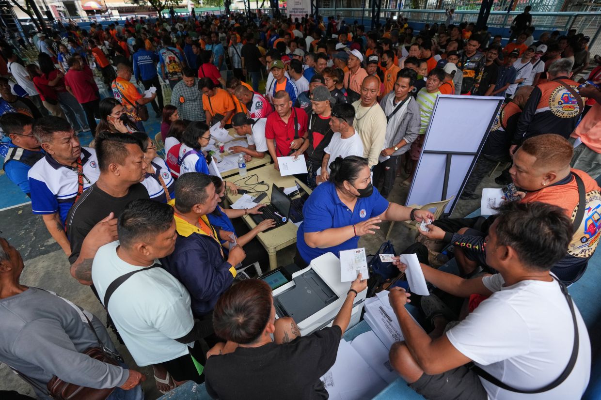 Tricycle drivers prepare their documents to receive government cash assistance to support their livelihoods as oil prices continue to rise on Tuesday, March 17, 2026, in Manila, Philippines. -- AP Photo/Aaron Favila