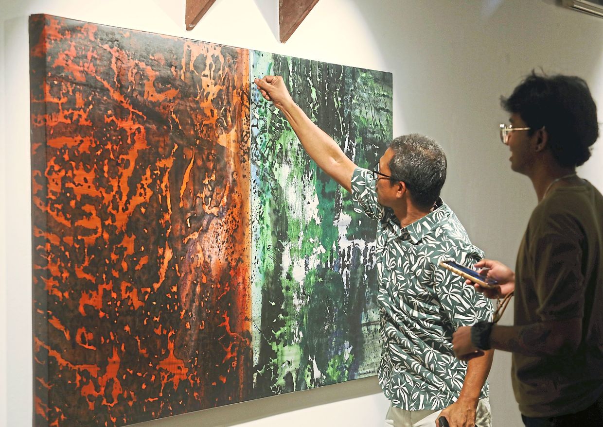 'Starting a painting is a bit like writing a script, there’s a narrative I want to share,' says Hamidi, pointing to a work titled 'Held Together'. Photo: The Star/Azlina Abdullah 