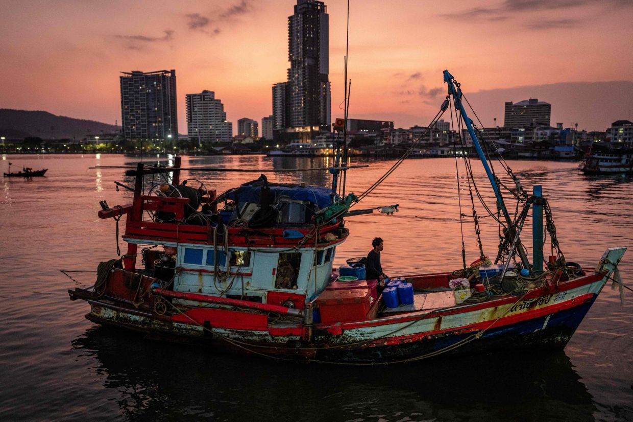 A man stands on a fishing boat docked at a pier in Si Racha on March 18, 2026. Fishermen in Thailand benefit from tax-exempt diesel, known as green oil, which costs less than 20 baht ($0.60) per litre before the war broke out in the Middle East on February 28. It now costs 35 baht and is increasingly hard to find, with boats of hundreds of fishers stuck at the dock because of surging diesel prices. -- Photo by Chanakarn LAOSARAKHAM / AFP