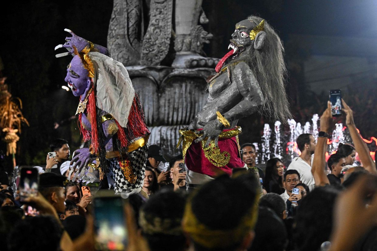 Hindu devotees carry effigies called - ogoh-ogoh - symbolising an evil spirit, during a parade on the eve of Nyepi, the Day of Silence that marks the New Year in the Balinese Hindu calendar, in Denpasar, Bali, on Wednesday, March 18, 2026. -- Photo by Sonny TUMBELAKA / AFP