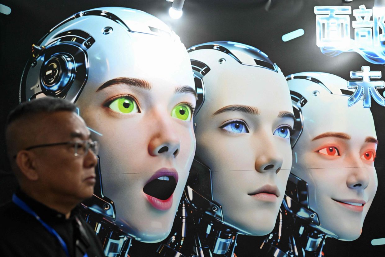 A man stands next to a poster showing robots mimicking human expressions from Shenzhen Xiaoquan Technology during the International AI Application and Robotics Innovation Exhibition in Beijing on Wednesday, March 18, 2026. -- Photo by ADEK BERRY / AFP