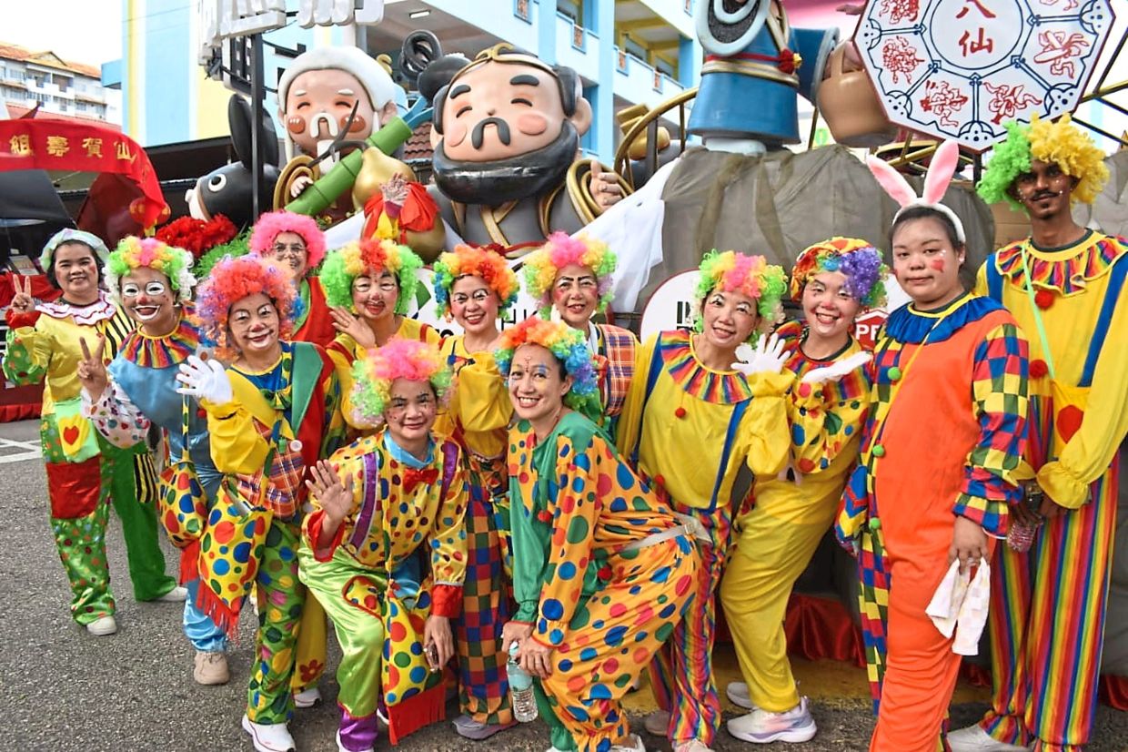 Janan Mohan (right) dressed up as a clown with the Johor Baru Hainan Association to bring laughter to the people during the festival in Johor Baru.