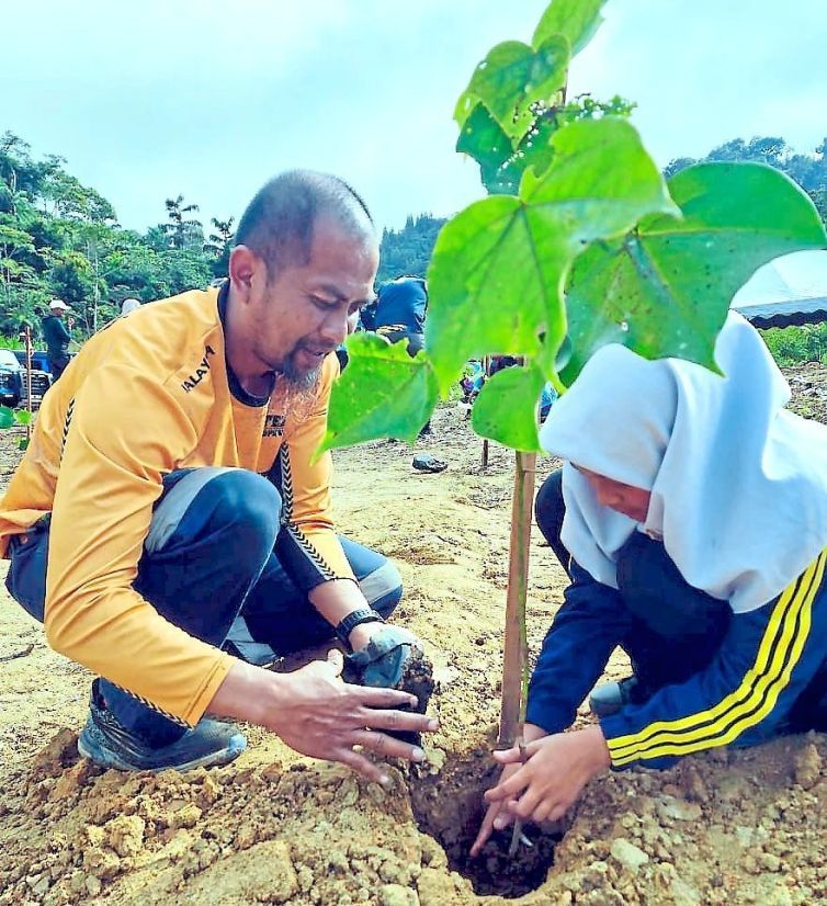 Volunteers planting a sapling during the tree-planting programme at Sungai Ichat Forest Reserve in Cameron Highlands.