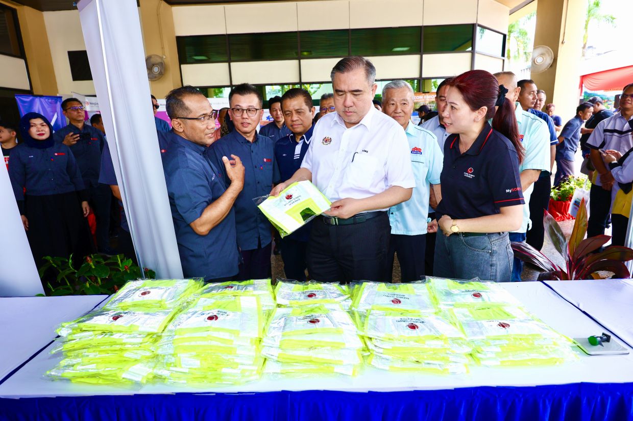 Transport Minister Anthony Loke inspects the safety vests which were distributed to participating road users. 