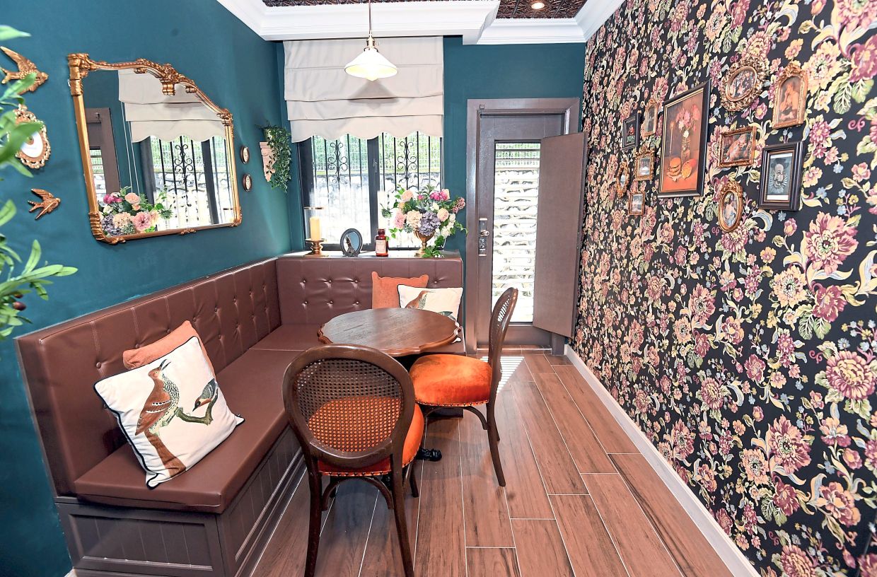 The cosy ‘cafe-style’ nook is next to the wallpapered hidden door to the man cave.