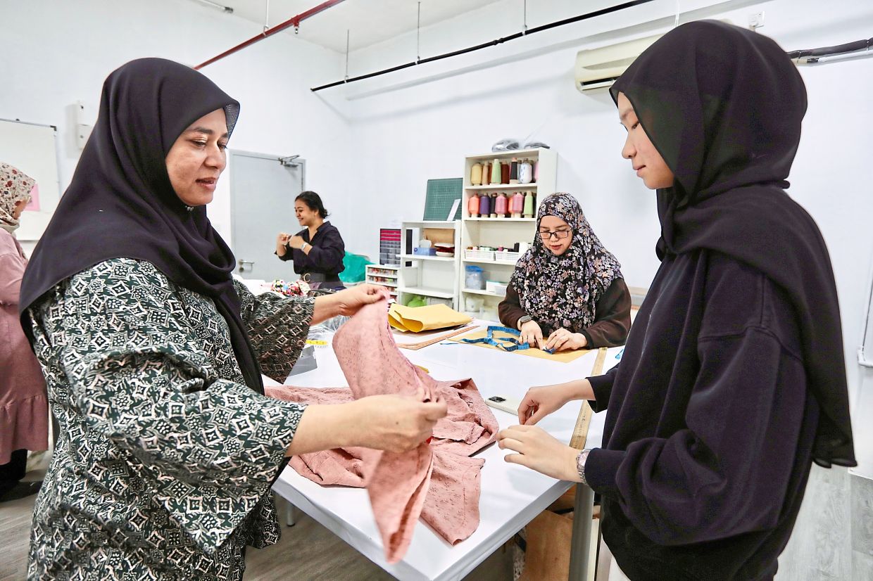 As prices for new Hari Raya attire increase, Wan Nur Hayati (left) believes sewing your own is more financially sustainable. Photo: The Star/Low Lay Phon