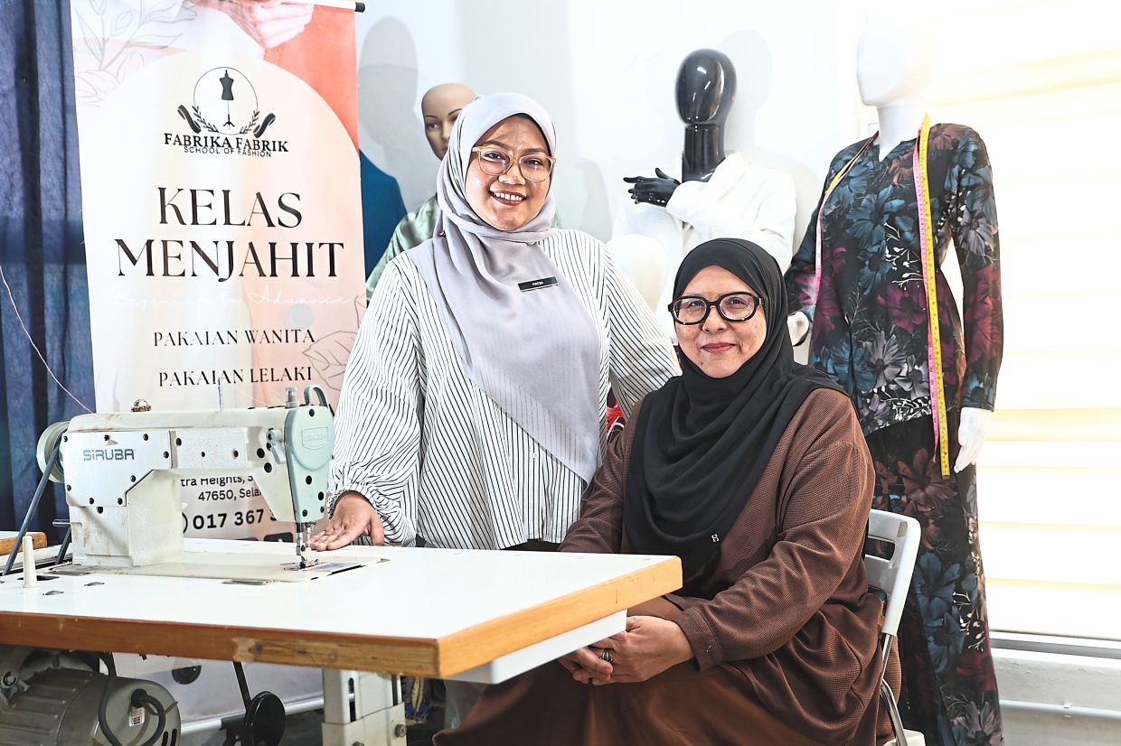 Wan Nor Zalinda (right) and NurFatin want to ensure the sewing craft is passed on to the next generation. Photo: The Star/Azman Ghani