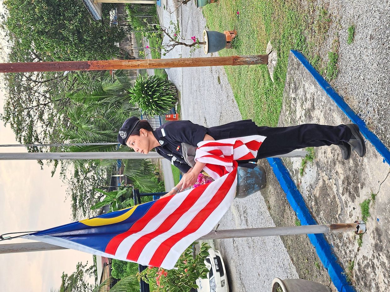 Prof Cheah in police volunteer uniform during a ceremonial duty at a police station. 